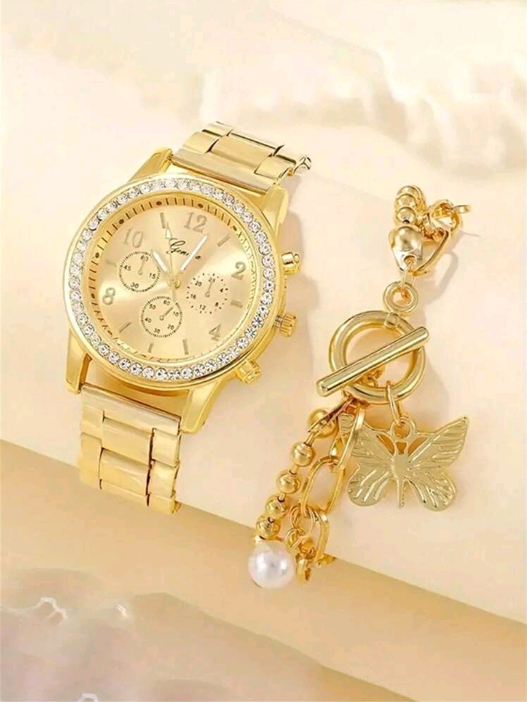 RELOJ AMARILLO METAL CO DIAMENTES ALREDEDOR NUM GRANDES CON PULSERA CON DIJE DE MARIPOSA Y PERLA R22